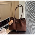 Close-up of brown suede tote bag featuring a leather buckle and a cute bear charm - Coffee with Pendant