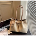 Detail of beige suede tote bag featuring brown leather straps and a fuzzy bear charm - Cream White With Pendant