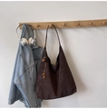 Detaillierte Ansicht der dunkelbraunen Totetasche mit Vintage-Textur und Holzperlenanhänger - Kaffee mit Anhänger