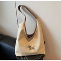 Close-up of zebra embroidery on beige canvas hobo bag with brown leather strap - One Size / Khaki