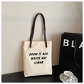 Dettaglio della borsa tote in tela color crema con manici in pelle marrone e stampa nera - Bianco Sporco
