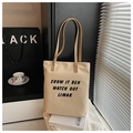 Dettaglio ravvicinato della borsa tote in tela beige con stampa nera in stile minimalista - Cachi