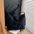 Matte schwarze Tragetasche mit Knotendekor und weißen Nähten in elegantem Licht - Schwarz