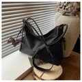 Detail of a black hobo bag with a cute dachshund charm in a warm lifestyle setting - Black with Pendant