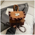 Detalle de una mini mochila marrón vintage de gamuza con volantes y dije de oso - Marrón