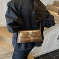 Bolso de hombro marrón retro con hebilla plateada grande mostrado por una modelo - Marrón
