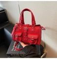 Dettaglio borsa in pelle rossa a grana con tracolla rimovibile e tasche con fibbia - Rosso