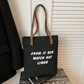 Borsa tote in tela nera con cinturini in pelle marrone su una valigia argentata interna - Nero
