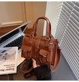 Dettaglio della borsa in pelle marrone martellata con tasche cargo e fibbie argento - Marrone
