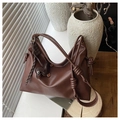 Detailed close-up of dark brown soft leather tote bag with stylish knot straps and charms - Brown with Pendant