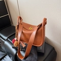 Bolso tipo almohada de cuero sintético marrón con cierre dorado y pompón decorativo - Marrón