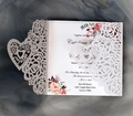 Details lasergeschnittener Rosen und Herzmuster auf edler weißer Hochzeitseinladung - Weiß