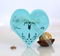 Macro shot of light blue heart-shaped laser-cut candy box with ribbon and floral patterns - Tiffany Blue