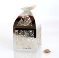 Macro view of silver laser-cut wedding favor box with intricate rose and butterfly patterns - Reflective Silver