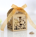 Macro detail of laser-cut lovebird candy box with kraft texture and golden silk ribbon - Beige Gold