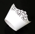 Macro detail of laser-cut white lace cupcake wrappers featuring floral hollow pattern - White