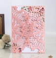 Detail of laser-cut pink wedding invitation with floral inner card and white rose deco - Pink
