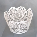 Macro shot of white laser-cut cupcake wrapper with intricate heart and leaf patterns - White