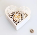 Close-up of laser-cut heart favor box with rose patterns and white satin ribbon - Ivory