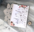 White laser cut floral wedding invitation with rose insert on marble background - White