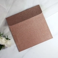 Makroaufnahme eines quadratischen Umschlags in Roségold-Glitzer auf weißem Marmor - Quadratisch / Roségold
