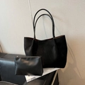 Minimalist black suede tote bag set with matching zipper pouch on leather sofa - Black