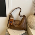 Dark brown half-moon tote bag with a cute plush bear pendant and textured synthetic leather - Brown with Pendant