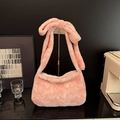 Pink plush faux fur tote bag featuring a large bow shoulder strap for autumn fashion - Pink