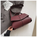 Detailed view of burgundy leather handbag with textured pebble grain and metal clasp - Red