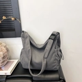 Gray corduroy tote bag with adjustable strap on leather bench in a modern room - Gray