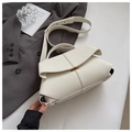 Detailed shot of white lychee leather texture and golden metal buckle on shoulder bag - White