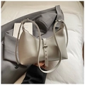 Detalle del bolso hobo gris con correa vertical y remaches metálicos decorativos - Gris