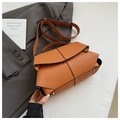 Detail of tan pebble leather bag featuring geometric flap and white contrast stitching - Brown
