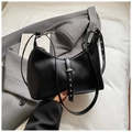 Detalle de bolso medialuna negro con remaches plateados y correa ajustable moderna - Negro