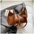 Detalle de bolso hobo de cuero marrón con correa de remaches y herrajes metálicos plata - Marrón
