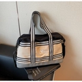 Close-up of tricolor travel bag featuring striped webbing and circular logo on leather surface - One Size / Black