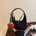 Sac hobo noir minimaliste avec pompon décoratif présenté sur un fond en bois - Avec Pendentif / Noir