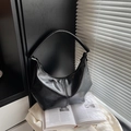 Sac hobo demi-lune en similicuir noir avec bandoulière large sur fond de magazine minimal - Noir