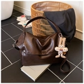 Dettaglio della borsa hobo retrò marrone scuro con texture in pelle e ciondolo a coniglio - Caffè con Ciondolo
