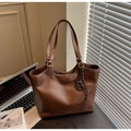 Detail of dark brown faux leather tote bag with vintage texture and brand logo - With Charm / Brown