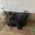 Minimalist black faux suede crossbody hobo bag with vintage floral pendant on wooden table - Black with Pendant