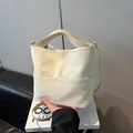 Minimalistische cremeweiße Eimertasche aus Leder mit vertikalen Nähten und Griff - Weiß