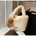 Detail of white faux shearling bucket bag with a brown teddy bear charm and logo tag - Beige (With Bear Pendant)