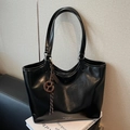 Minimalist black leather tote bag with woven ball charm and brand logo detail - With Charm / Black
