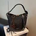Black bucket bag with woven handle and adjustable strap on elegant book props - With Charm / Coffee