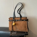 Brown suede tote bag with black leather straps and Muon Shark logo on a sofa - With Charm / Brown