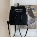 Black canvas backpack featuring 'Honey Cute' embroidery and leather straps hanging on a wall - Black