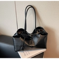 Macro detail of black leather tote bag featuring natural grain texture and strap buckle - Black