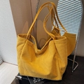 Yellow corduroy tote bag with vertical texture and long shoulder strap in a cozy setting - Yellow