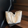 Minimalist beige corduroy tote bag shown on wooden steps with elegant lifestyle aesthetic - Off White